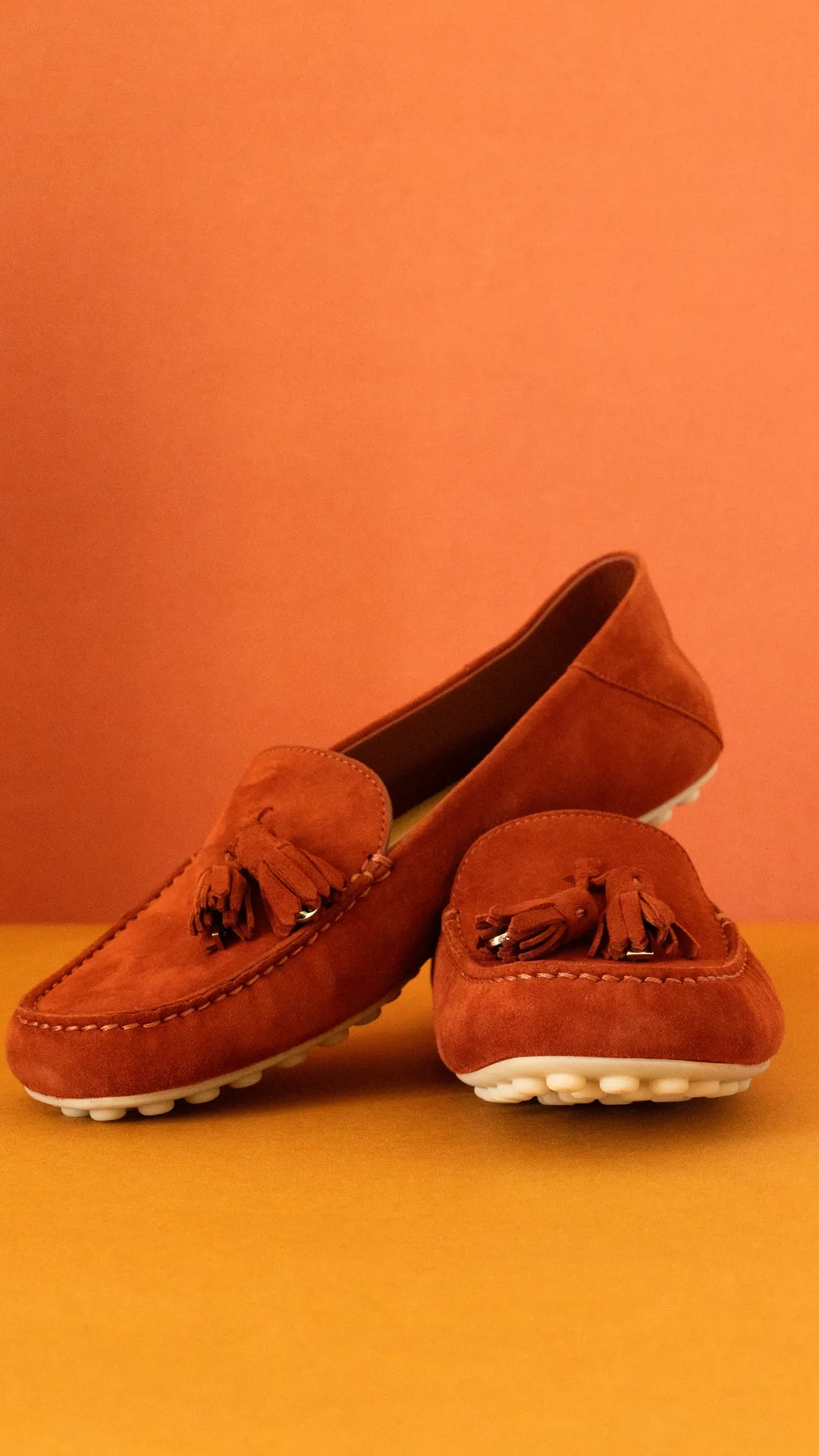 Moccasin-style slipper on an orange studio background